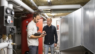 Coopérative d’habitation de la Paix à Nyon: une pompe à chaleur air/eau assure le chauffage de la maison locative. Sur la photo: Tobia Wyss et Roman Joye (Impact Living).