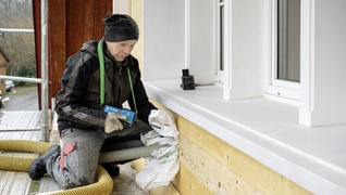 Hinter die Schindelfassade eines denkmalgeschützten Appenzeller Hauses wird Zellulose geblasen.