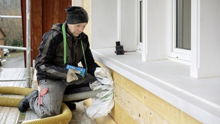 De la cellulose est pulsée derrière la façade en bardeaux d’une maison d’Appenzell protégée au titre de monument historique.