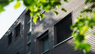 Das Mehrfamilienhaus in Ostermundigen (BE) erhielt durch die energetische Sanierung eine neue Holzfassade, die auch ästhetisch ein Gewinn ist.